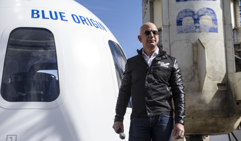 Blue Origin founder Jeff Bezos speaks in front of his company's New Shepard suborbital vehicle. Image: SpaceNews/Chuck Bigger)
