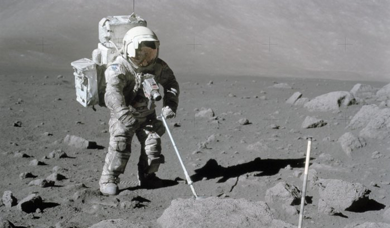 NASA astronaut Harrison Schmitt uses scoop to retrieve lunar samples during the Apollo 17 mission in 1972. The dust is clearly evident over the vast majority of his suit. Image: NASA