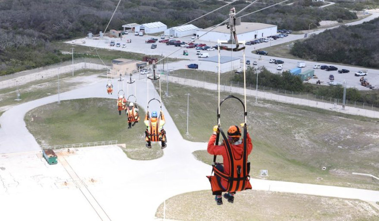 Engineers test and evaluate the Emergency Egress System (EES) as they ride in seats attached to slide wires at Space Launch Complex 41. Credit: NASA/Leif Heimbold 