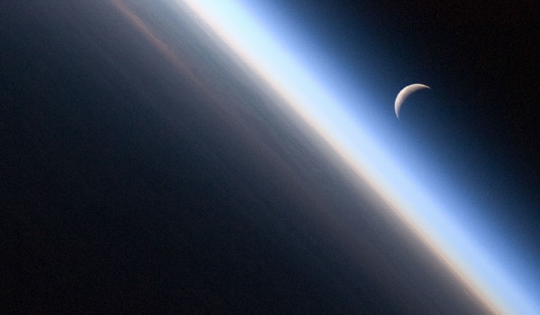 A setting crescent Moon and the thin line of Earth’s atmosphere viewed from the International Space Station