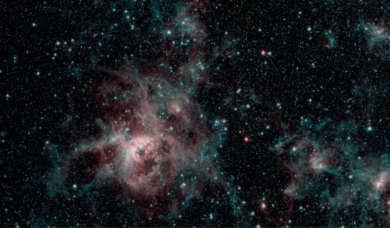 Spitzer image showing the Tarantula nebula in two wavelengths of infrared light - red regions indicate the presence of particularly hot gas and blue are interstellar dust, similar in composition to ash from coal or wood-burning fires on Earth.