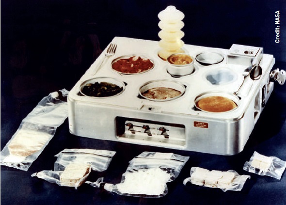 The Skylab food heating and serving tray from 1970, complete with food, drink, and utensils.