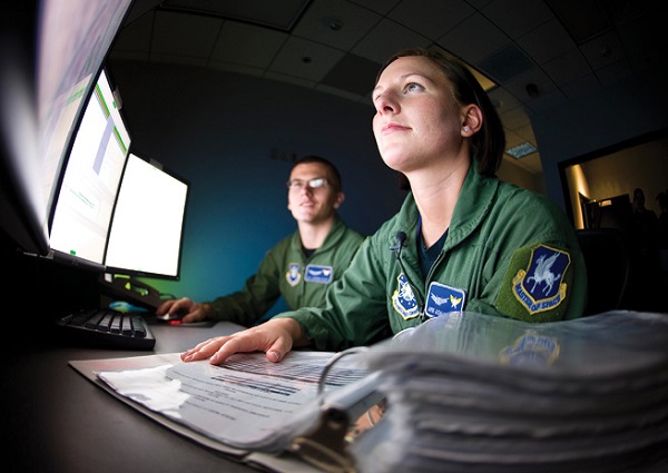 Airman Ashley Risk (foreground) and Airman 1st Class Jasper Platt oversee a satellite system procedure at Schriever Air Force Base, Colorado. They are space ground link operators with the 4th Space Operations Squadron