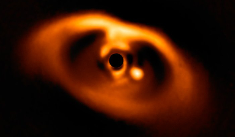 This spectacular image from the SPHERE instrument on ESO's VLT is the first clear image of a baby planet around the dwarf star PDS 70 (blacked out by the coronagraph mask to block the light from the young star). Image: ESO/A. Müller et al.