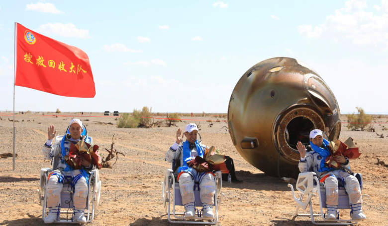 Chinese astronauts from left, Tang Hongbo, Nie Haisheng and Liu Boming wave at the Dongfeng landing site in the Gobi Desert on 17 September, 2021. Image: Xinhua News Agency,