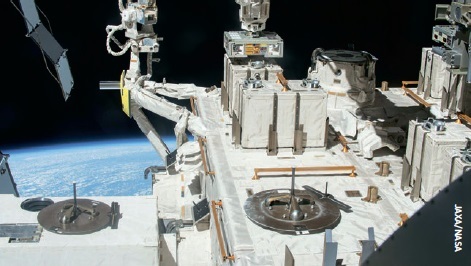 A robotic arm places samples of radioresistant Deinococcus bacteria outside the International Space Station