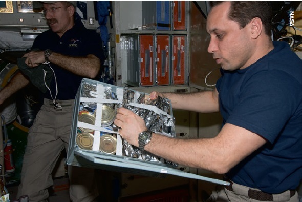 Cosmonaut Anton Shkaplerov taking food out of a container