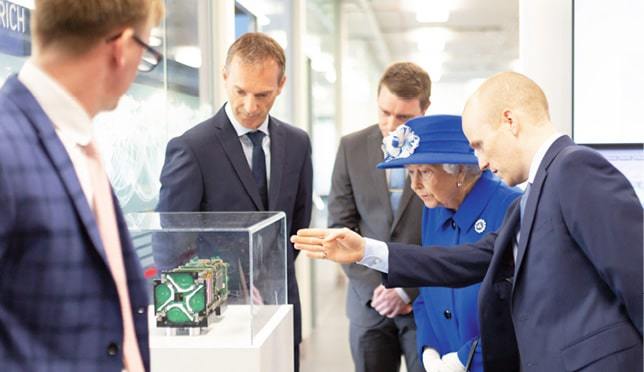 Joel Spark shows Her Majesty Queen Elizabeth II a Spire satellite