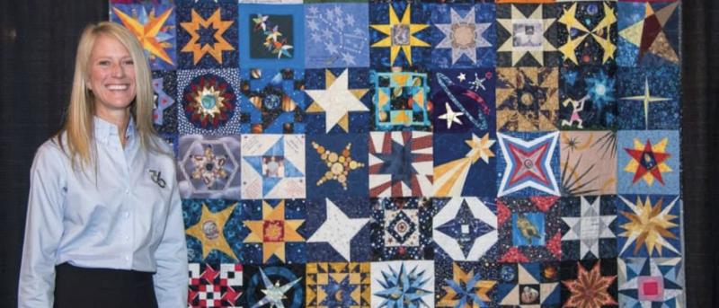 Karen Nyberg poses in front of a starry quilt at the International Quilt Festival in Houston, Texas, in 2014.