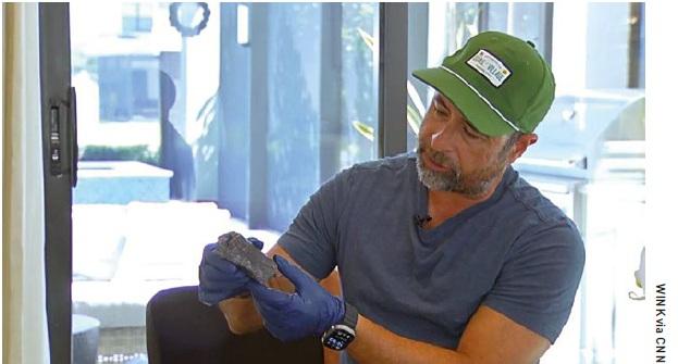 Alejandro Otero holds the piece of debris that hit his house in March 2024