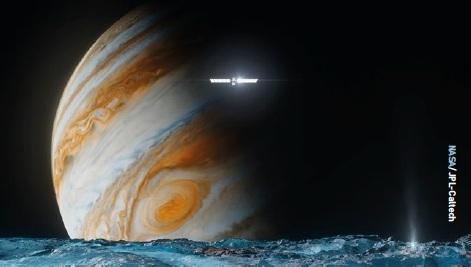 Illustration of NASA’s Europa Clipper spacecraft above the surface of Europa and in front of Jupiter.