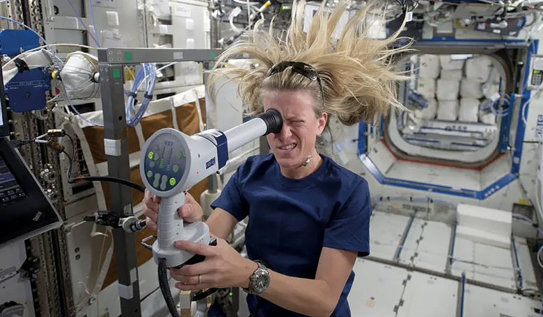 NASA astronaut Karen Nyberg uses a fundoscope to image her eye while in orbit. Examining the retina in this way helps scientists track how the spaceflight environment affects the human eye.